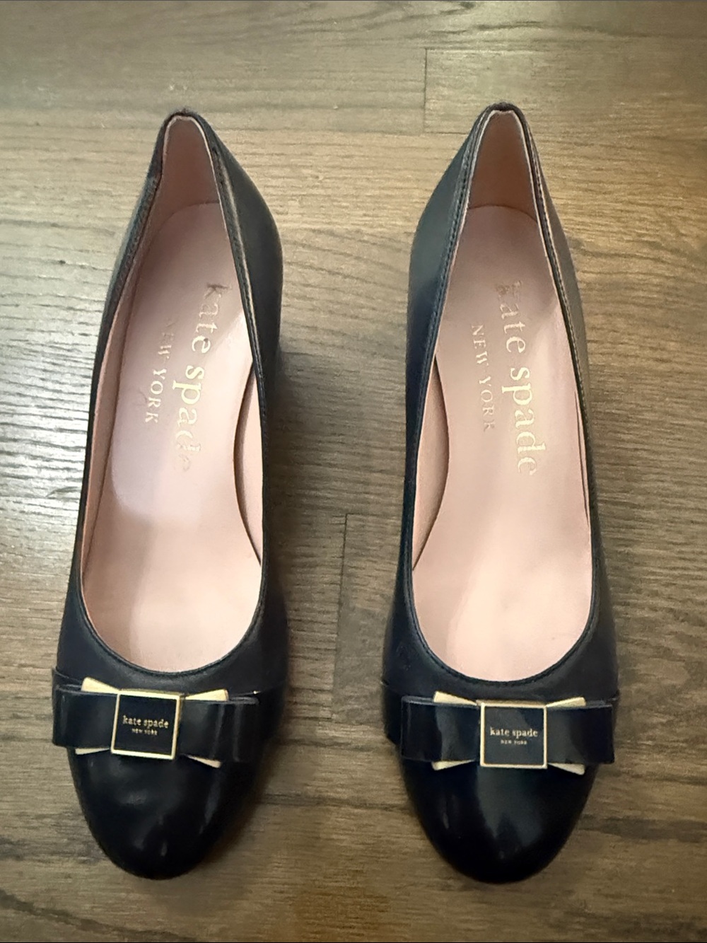 kate spade navy leather pumps with bow and gold-tone plaque-